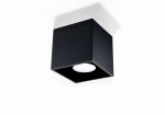 Czarna lampa sufitowa 1-punktowa Quad z kwadratowym korpusem. Ujęcie z dołu, ukazujące wnętrze lampy z białym źródłem światła. Gładka, matowa powierzchnia, prosty design, zamontowana na suficie.