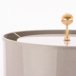 Lampa stołowa Cartagena 2-punktowa T02004AU w kształcie okrągłej abażuru w kolorze szaro-beżowym z metalowym, złotym uchwytem. Widoczna górna część z przezroczystym kloszem i dekoracyjnym złotym kulistym elementem.