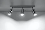 Lampa sufitowa 3-punktowa w chromowanym wykończeniu, z trzema cylindrycznymi reflektorami. Ujęcie z góry, pokazujące montaż na suficie oraz oświetlenie kierunkowe. Reflektory w pozycji ustawionej na różne kierunki. Tło proste, jasne.