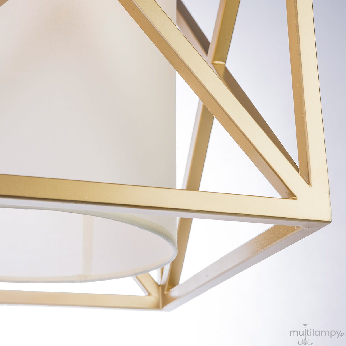 Lampa wisząca New York w kolorze złotym z metalowym stelażem w formie geometrycznej ramy, z białym abażurem. Ujęcie z dołu, pokazujące detale konstrukcji oraz kształt.