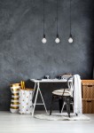 Czarna lampa wisząca 3-punktowa Fix Multiple z trzema przezroczystymi żarówkami, zawieszona na długich kablach. Produkt widoczny w nowoczesnym wnętrzu z jasnym biurkiem i dekoracyjnymi dodatkami, na tle szarej ściany.