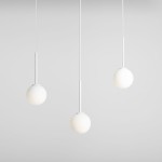 Lampa wisząca Bosso 3-punktowa, biała, składająca się z trzech okrągłych kloszy zawieszonych na cienkich białych przewodach. Klosze mają matową powierzchnię, a całość umieszczona jest na jasnym tle.