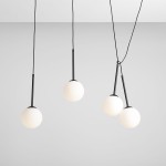 Czarna lampa wisząca Bosso z czterema punktami świetlnymi. Każdy z kloszy w kształcie kuli wykonany z matowego szkła, zawieszony na cienkich, czarnych linkach. Lampa wisi w prostej aranżacji na jasnym tle.