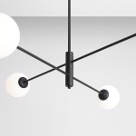 Czarna lampa wisząca 4-punktowa Homme z białymi, okrągłymi kloszami. Widok z dołu, ukazujący centralny element mocujący oraz rozłożone ramiona. Prosta, nowoczesna konstrukcja, umieszczona na jednolitym tle.