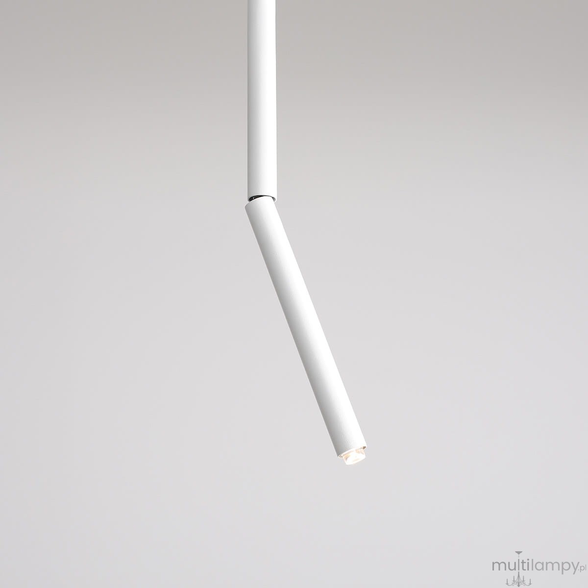 Biała lampa sufitowa Stick L z jednym punktem świetlnym, o prostym, cylindrycznym kształcie. Ujęcie z góry, pokazujące ruchomy element lampy. Tło w jasnym kolorze, podkreślające minimalistyczny design.