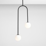 Lampa wisząca 2-punktowa Nave w kolorze czarnym, z dwoma okrągłymi kloszami w odcieniu białym. Ujęcie frontalne, produkt zawieszony na cienkim, zakrzywionym przewodzie, na jednolitym, jasnym tle.