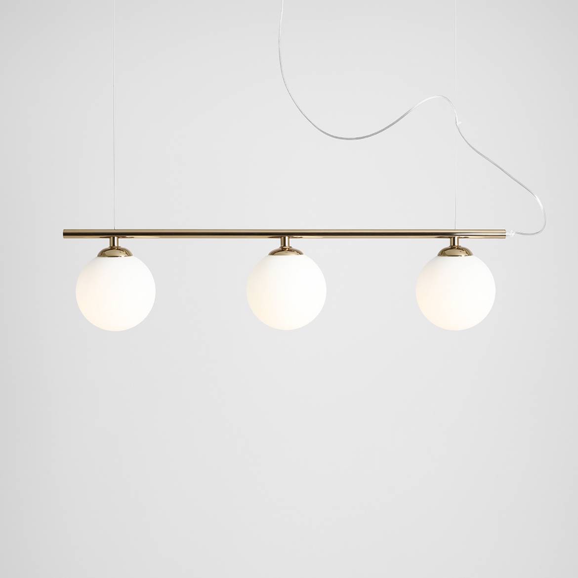 Lampa wisząca Beryl Glass 3-punktowa, złota, z trzema okrągłymi, mlecznymi kloszami. Produkt zawieszony na cienkim przewodzie, z metalowym stelażem. Prosty design na jasnym tle, idealny do nowoczesnych wnętrz.