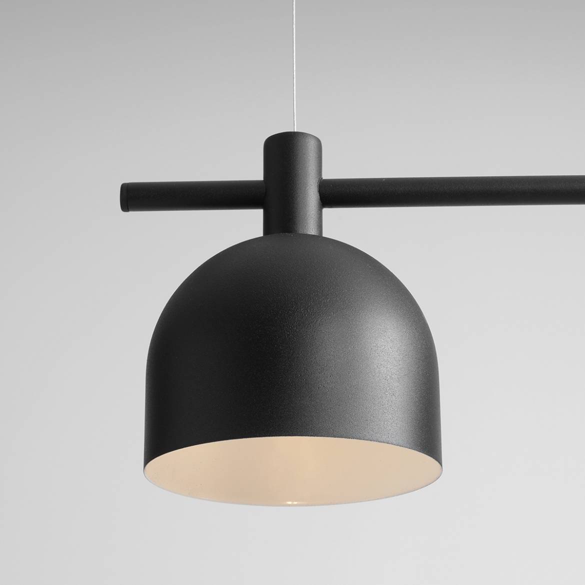 Lampa wisząca Beryl 2-punktowa w kolorze czarnym, z matową, zaokrągloną czaszą i prostą, poziomą belką. Ujęcie z góry, pokazujące detal konstrukcji i oświetlenia wewnętrznego. Idealna do nowoczesnych wnętrz.