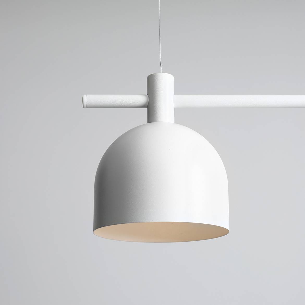 Biała lampa wisząca 3-punktowa Beryl, z okrągłym kloszem i prostą metalową konstrukcją. Produkt zawieszony na cienkim przewodzie, z minimalistycznym designem. Widoczny gładki, matowy wykończenie.