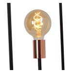 Czarna lampa podłogowa Arthur 3-punktowa z przezroczystą żarówką w mosiężnym uchwycie. Ujęcie z bliska na żarówkę z widocznym spiralnym włóknem. Prosta, nowoczesna konstrukcja z metalowymi nogami.