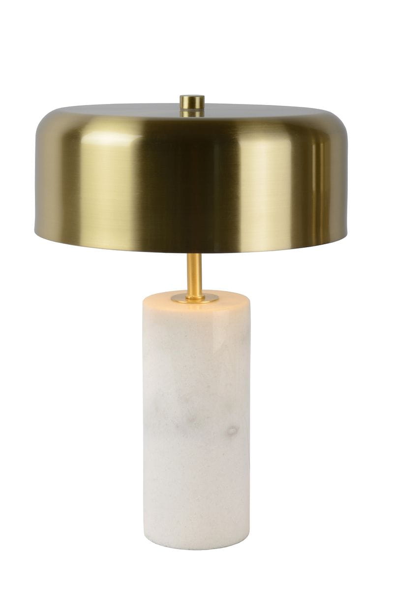 Lampa stołowa Mirasol 3-punktowa, z metalowym, złotym kloszem i białym, cylindrycznym podstawą z marmuru. Ujęcie frontalne, stojąca na jednolitym tle. Widoczny detal włącznika w centralnej części podstawy.