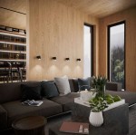 Lampa sufitowa Snow 1-punktowa LP-731/1W GD w kolorze złotym, zamontowana na drewnianej ścianie w nowoczesnym wnętrzu. Widoczne detale to minimalistyczny design i eleganckie wykończenie. W tle kanapa z poduszkami i stolik z roślinami.