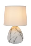 Lampa stołowa Marmo 1-punktowa w kolorze białym. Kształt owalny, wykonana z marmuru z delikatnym wzorem, z białym abażurem z tkaniny. Ujęcie frontalne, lampa stoi na płaskiej powierzchni. Idealna do biura lub sypialni.