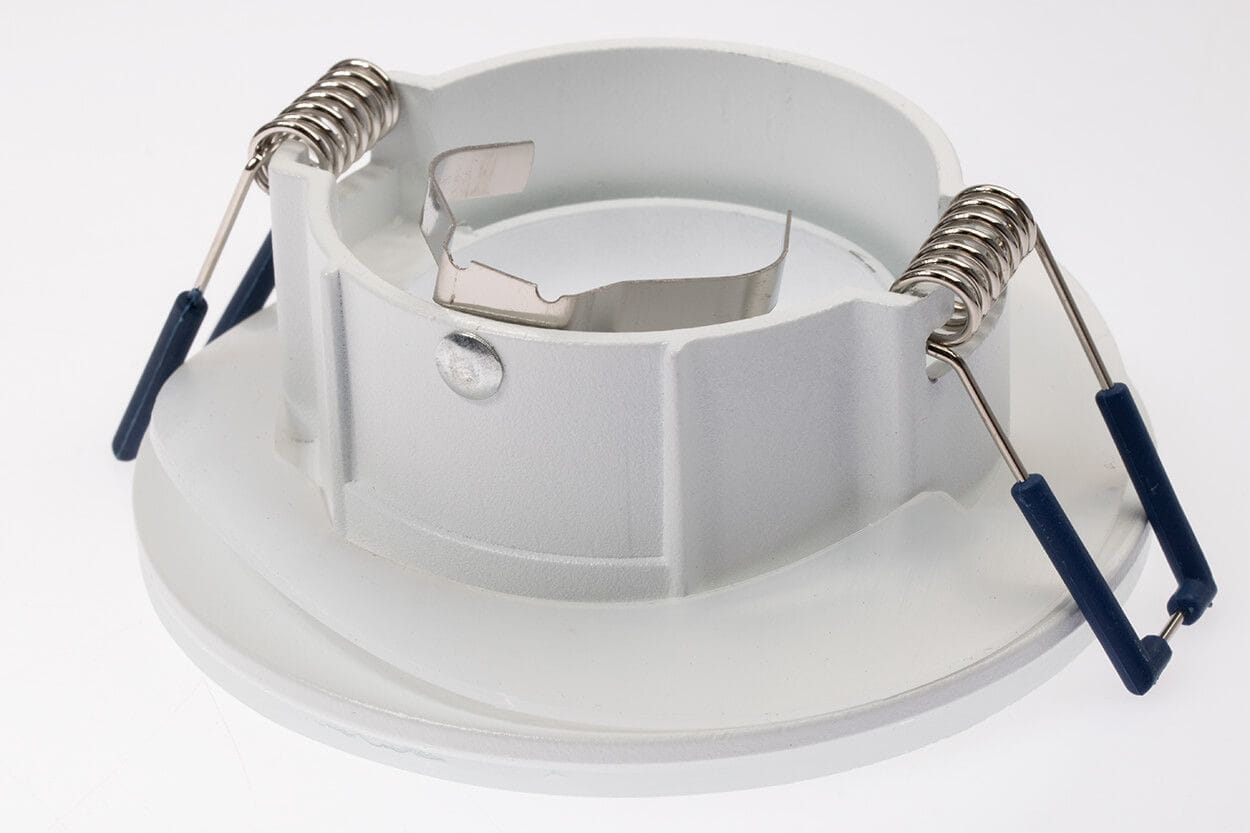 Oprawa oczko Aqua IP44 w kolorze białym, okrągła, z metalowymi sprężynami mocującymi. Widoczna jest górna część z otworem na źródło światła oraz krawędź oprawy. Produkt przeznaczony do zabudowy w sufitach.