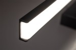 Czarny kinkiet łazienkowy Venus LED IP44, długość 60 cm, oświetlenie w formie prostokątnej listwy. Gładka, matowa obudowa z białym źródłem światła. Zbliżenie na krawędź lampy, umieszczoną na jednolitym tle.
