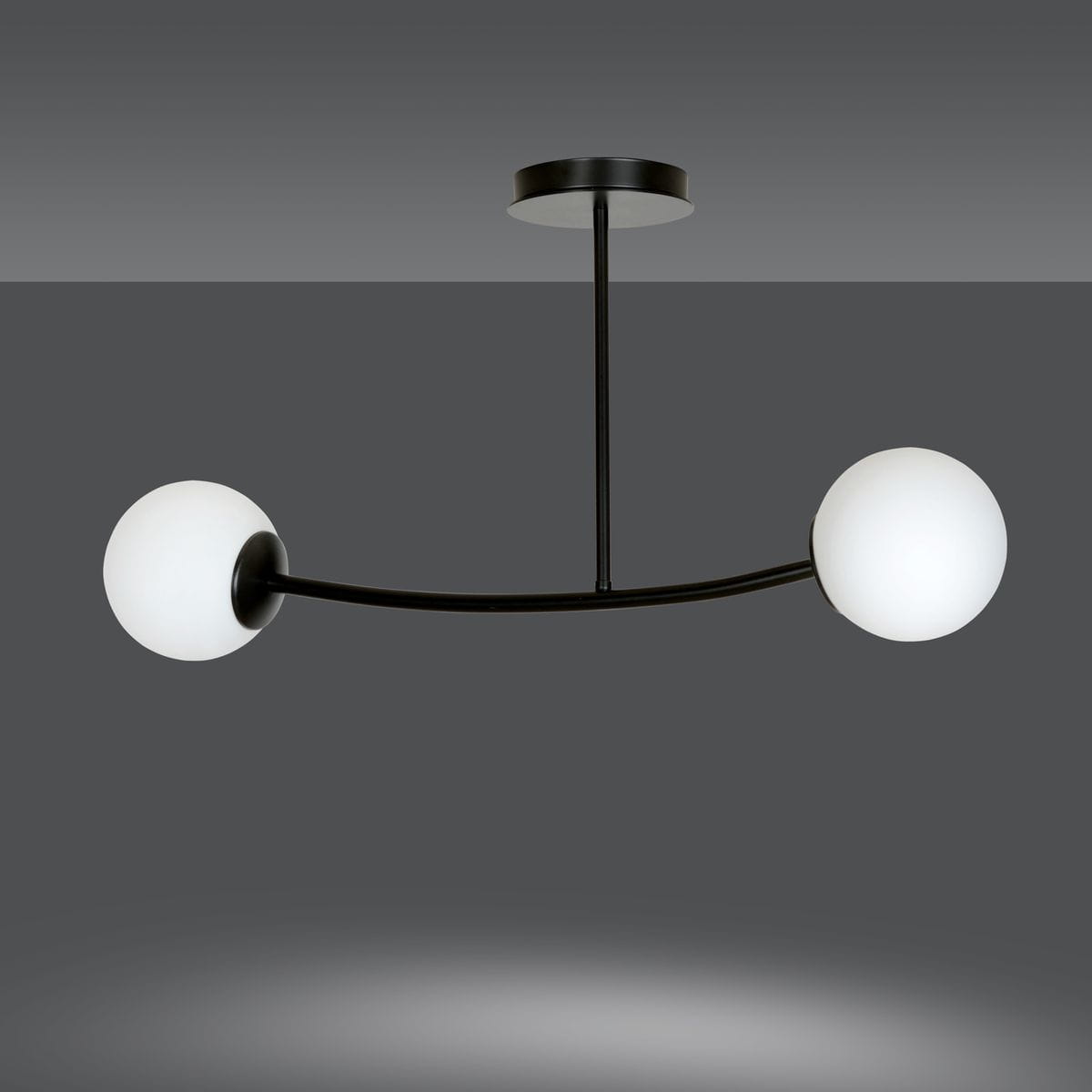 Lampa wisząca Halldor 2-punktowa w kolorze czarnym. Posiada dwa okrągłe klosze z białego szkła umieszczone na zakrzywionym ramieniu. Montaż sufitowy, minimalistyczny design, idealna do nowoczesnych wnętrz.