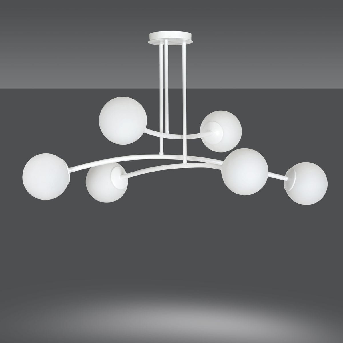 Lampa wisząca Halldor 6-punktowa w kolorze białym. Posiada sześć okrągłych, matowych kloszy na delikatnych, zakrzywionych ramionach. Ujęcie z dołu, produkt zamontowany na suficie, na ciemnym tle.