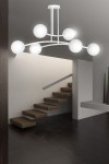 Lampa wisząca Halldor, 6-punktowa, w białym kolorze. Posiada sześć okrągłych kloszy w formie kul, umieszczonych na elastycznych ramionach. Zawieszona na suficie, w nowoczesnym wnętrzu z drewnianymi schodami.
