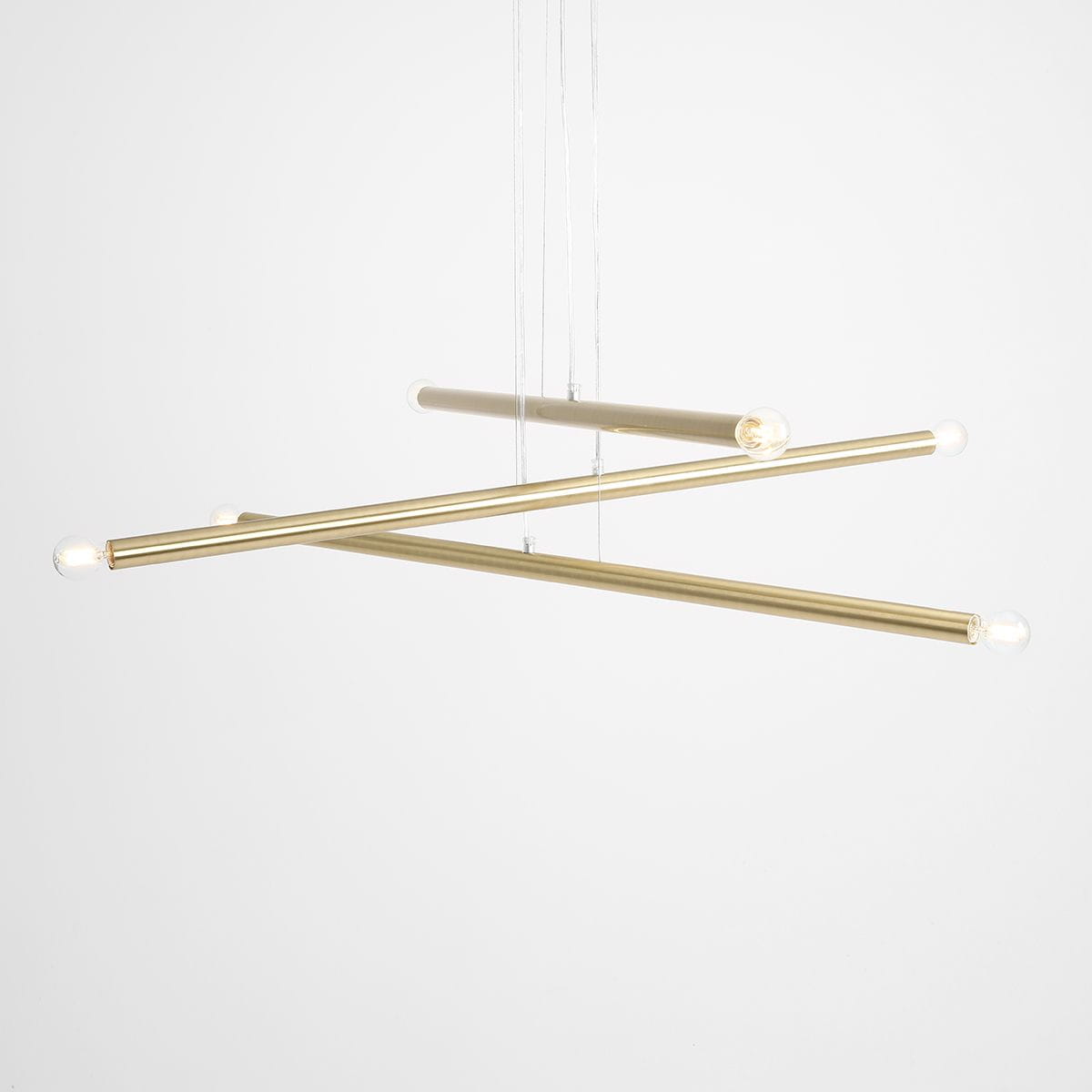 Lampa wisząca Tubo 6-punktowa w kolorze mosiądzu, składająca się z trzech poziomych rur w różnych pozycjach, z widocznymi źródłami światła na końcach. Zawieszona na cienkich żyłkach, na jasnym tle.