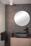 Biała lampa sufitowa Aven IP65, okrągła, zamontowana na suficie, o minimalistycznym designie. Widoczna w nowoczesnej łazience, w otoczeniu lustra, umywalki oraz ręcznika. Tło w odcieniach szarości podkreśla elegancję produktu.