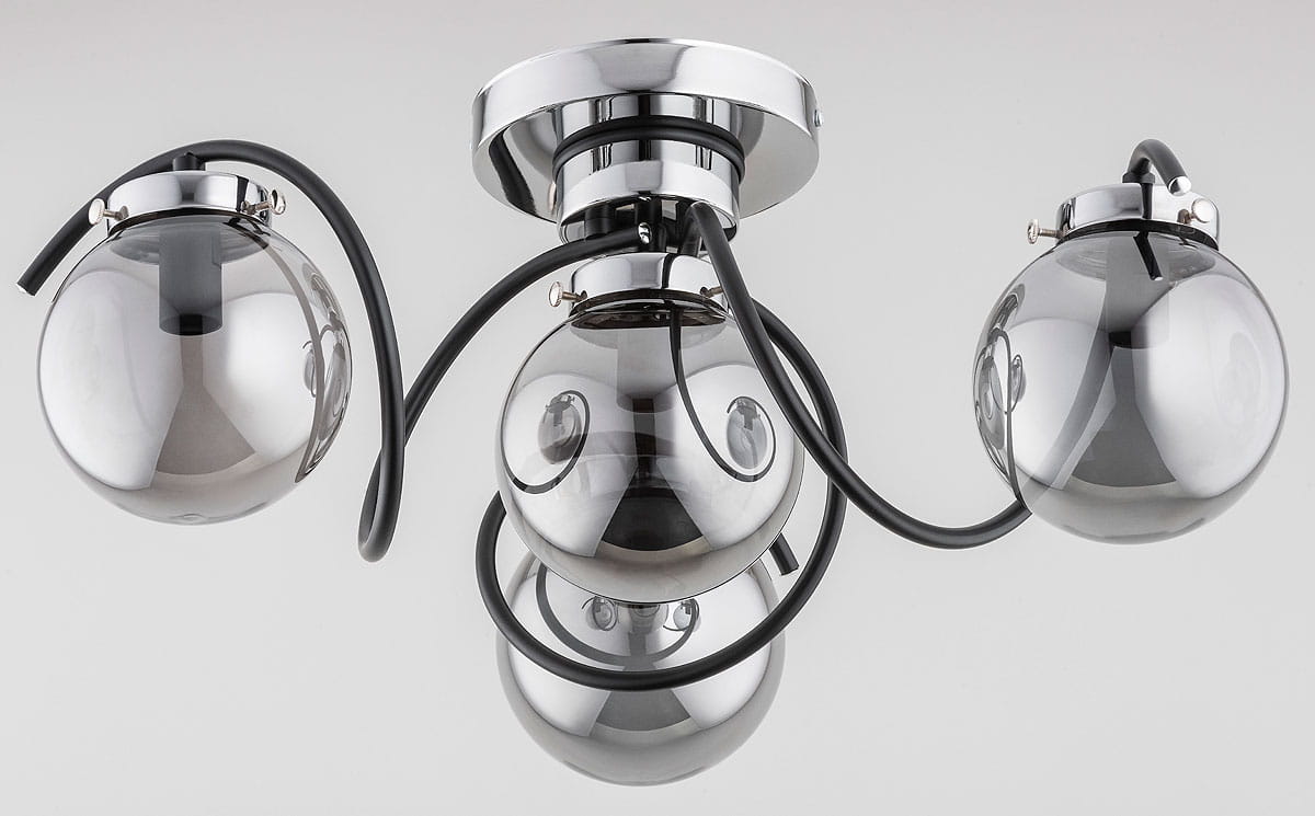 Lampa sufitowa Kretka z czterema oprawami E14, w kolorze czarnym i chromowanym. Posiada okrągłe, szklane klosze w chromowanym wykończeniu, zamocowane na elastycznych ramionach. Ujęcie z dołu, pokazujące detale konstrukcji i kształt.