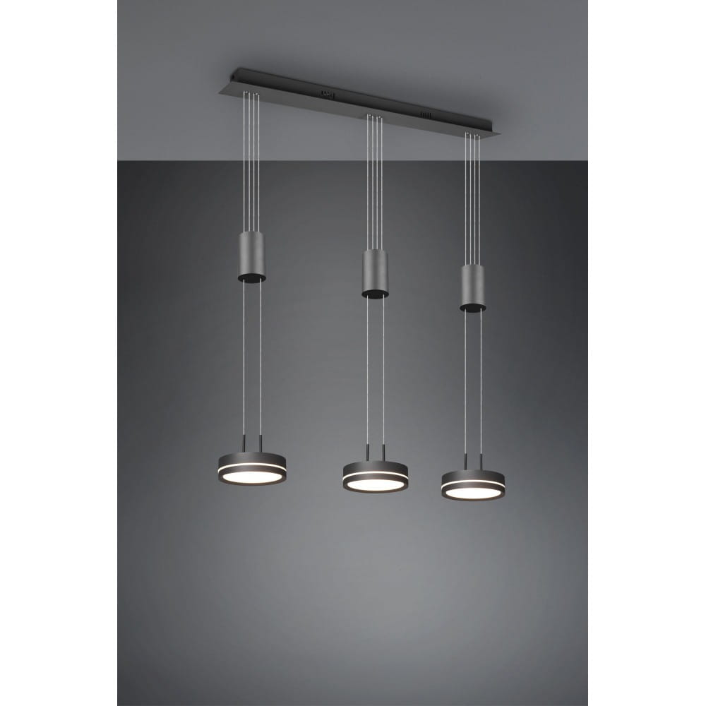 Lampa wisząca Franklin LED 3-punktowa w kolorze antracytowym. Trzy okrągłe źródła światła zawieszone na cienkich linkach, montowane do sufitu. Prosty, nowoczesny design. Tło w odcieniach szarości.