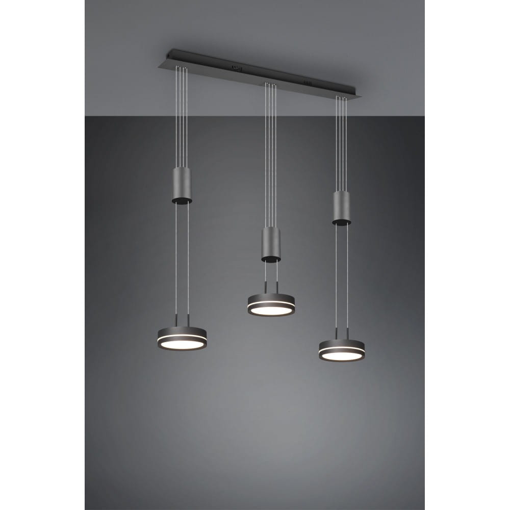 Franklin LED lampa wisząca 3-punktowa w kolorze antracytowym, zawieszona na cienkich linkach. Posiada trzy okrągłe źródła światła, zamocowane na prostokątnej podstawie. Tło w odcieniach szarości, podkreślające nowoczesny design.