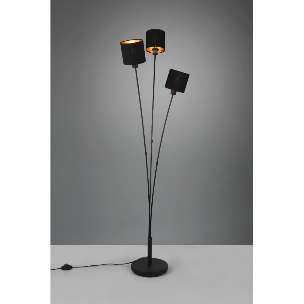 Czarna lampa podłogowa Tommy z trzema punktami świetlnymi, umieszczona na okrągłej podstawie. Klosze są cylindryczne, z metalicznym wykończeniem wewnętrznym. Kabel z włącznikiem widoczny u podstawy lampy. Ujęcie frontalne na jednolitym tle.