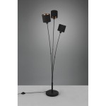 Czarna lampa podłogowa 3-punktowa Tommy z trzema cylindrycznymi kloszami, wyposażona w smukłe, metalowe ramiona. Ustawiona na okrągłej podstawie, z widocznym przewodem z włącznikiem. Tło w odcieniach szarości.