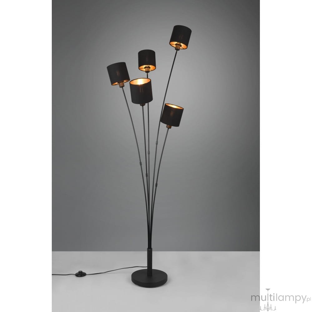 Czarna lampa podłogowa Tommy z pięcioma punktami świetlnymi, zamocowana na smukłych metalowych ramionach. Okrągła podstawa, widoczny kabel z włącznikiem. Klosze w formie cylindrów, z wewnętrzną mosiężną powłoką, na szarym tle.