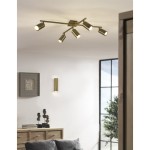 Lampa sufitowa Marley, 5-punktowa, w kolorze antycznego mosiądzu. Zawiera pięć regulowanych reflektorów umieszczonych na metalowej konstrukcji. Zamontowana na suficie, w nowoczesnym wnętrzu z drewnianymi meblami i dekoracjami.