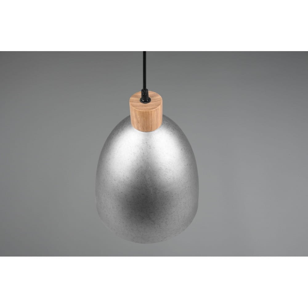 Lampa wisząca Jagger D25 w kolorze antycznego niklu z drewnianym elementem u góry. Ma kształt owalnej czaszy, zawieszona na cienkim przewodzie. Tło w odcieniach szarości, podkreślające nowoczesny design.