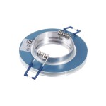 Okrągła oprawa do zabudowy GU10, transparentna, z metalowym wykończeniem. Widoczne sprężyny mocujące oraz niebieskie elementy. Produkt ustawiony na płaskiej powierzchni, ukazujący detal konstrukcji i mocowania.