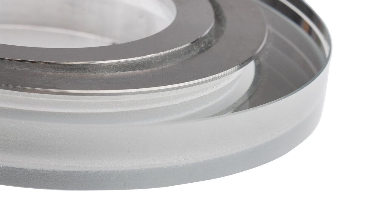 Okrągła, ruchoma oprawa oczko do zabudowy GU10 w kolorze transparentnym. Zbliżenie na detal struktury, z matowym i błyszczącym wykończeniem, widoczny metaliczny brzeg. Produkt leży na białym tle.