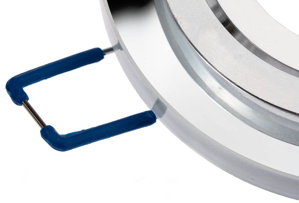 Okrągła, ruchoma oprawa oczko do zabudowy GU10 w kolorze transparentnym. Widoczny metalowy pierścień z połyskiem oraz niebieskie uchwyty mocujące. Ujęcie z boku, ukazujące szczegóły konstrukcji.