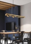 Lampa wisząca Bell 4-punktowa w kolorze antycznego niklu, z prostokątnym, metalowym korpusem i czterema regulowanymi źródłami światła. Zawieszona nad drewnianym stołem w nowoczesnym wnętrzu, na tle ciemnej ściany i telewizora.