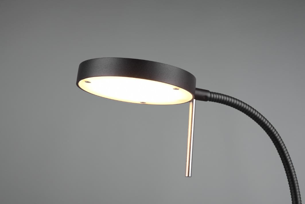 Czarna lampka biurkowa Monza LED z okrągłą głowicą emitującą ciepłe światło, elastycznym ramieniem oraz metalowym uchwytem. Widok z góry, podkreślający nowoczesny design i funkcjonalność. Tło szare, minimalistyczne.