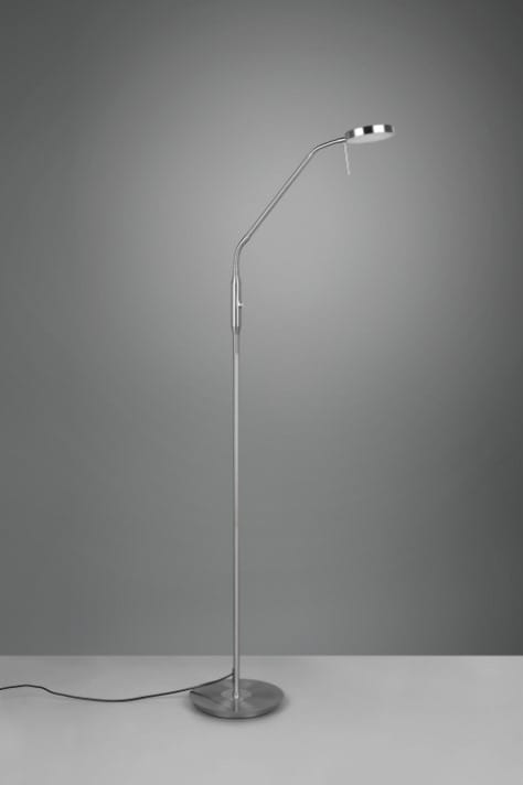 Lampa podłogowa Monza LED w kolorze niklowym, z cienką, wygiętą nogą i okrągłą podstawą. Głowica lampy z regulacją kierunku światła, umieszczona na długim ramieniu. Prosty, nowoczesny design, stojąca na szarym tle.