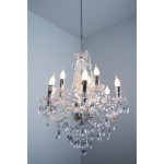 Luster żyrandol 9-punktowy, transparentny, z chromowanymi elementami, osiem źródeł światła z dekoracyjnymi kloszami, bogato zdobiony kryształkami, zwisający na łańcuchu, na jednolitym tle.