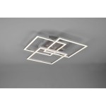 Trójpunktowa lampa sufitowa LED w kolorze niklowym, składająca się z nałożonych na siebie prostokątów, z ciepłym światłem. Ujęcie z góry, zamontowana na suficie, z pilotem do zdalnego sterowania.