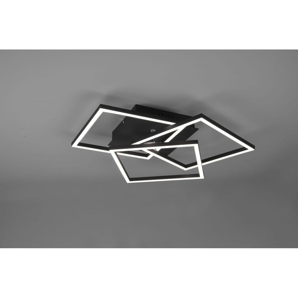 Czarna, 3-punktowa lampa sufitowa LED z pilotem, złożona z trzech geometrycznych kształtów w formie prostokątów, zamontowana na suficie. Lampa emituje światło w kolorze białym, z minimalistycznym designem.