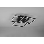 Czarna lampa sufitowa LED 3-punktowa z pilotem, składająca się z trzech geometrycznych ram w kształcie prostokątów, montowana na suficie. Elementy oświetleniowe mają białe krawędzie, a całość jest zamontowana na prostokątnej podstawie.