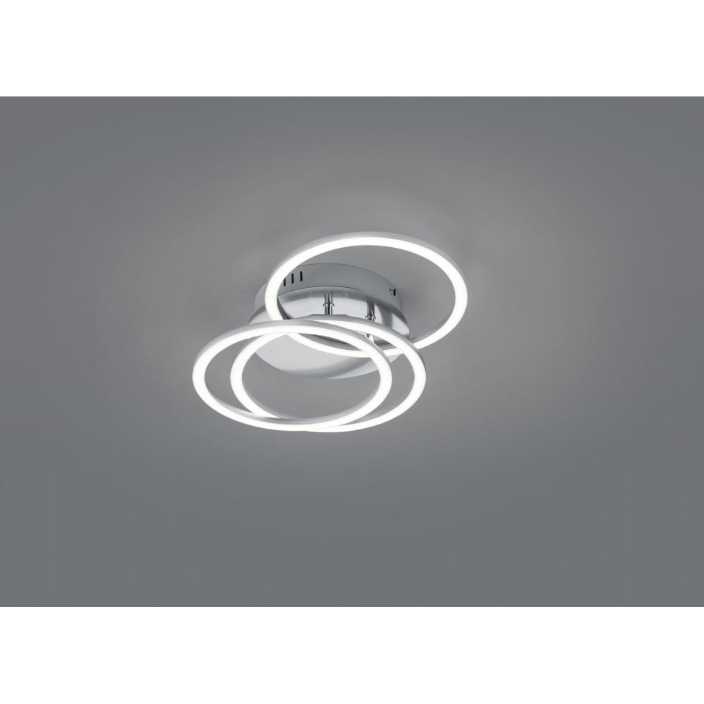 Trzy-punktowa lampa sufitowa LED w kolorze niklu, składająca się z trzech okrągłych pierścieni emitujących białe światło. Produkt zamontowany na suficie, z widocznym pilotem do zdalnego sterowania. Prostokątny kształt i nowoczesny design.