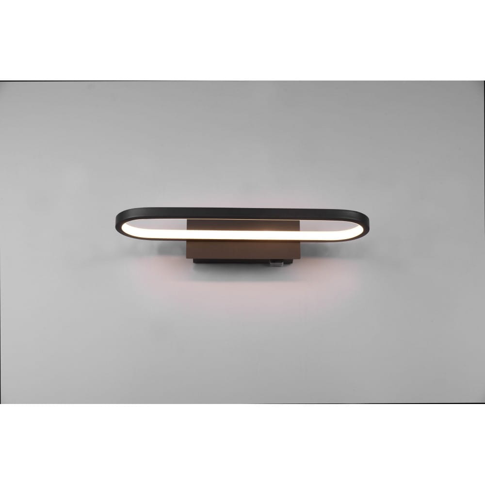 Czarny kinkiet łazienkowy Gianni LED IP44 o długości 40 cm i mocy 17 W, z okrągłym, podświetlonym kloszem. Montowany na ścianie, z minimalistycznym designem, idealny do oświetlenia wnętrz. Tło proste, jasne.