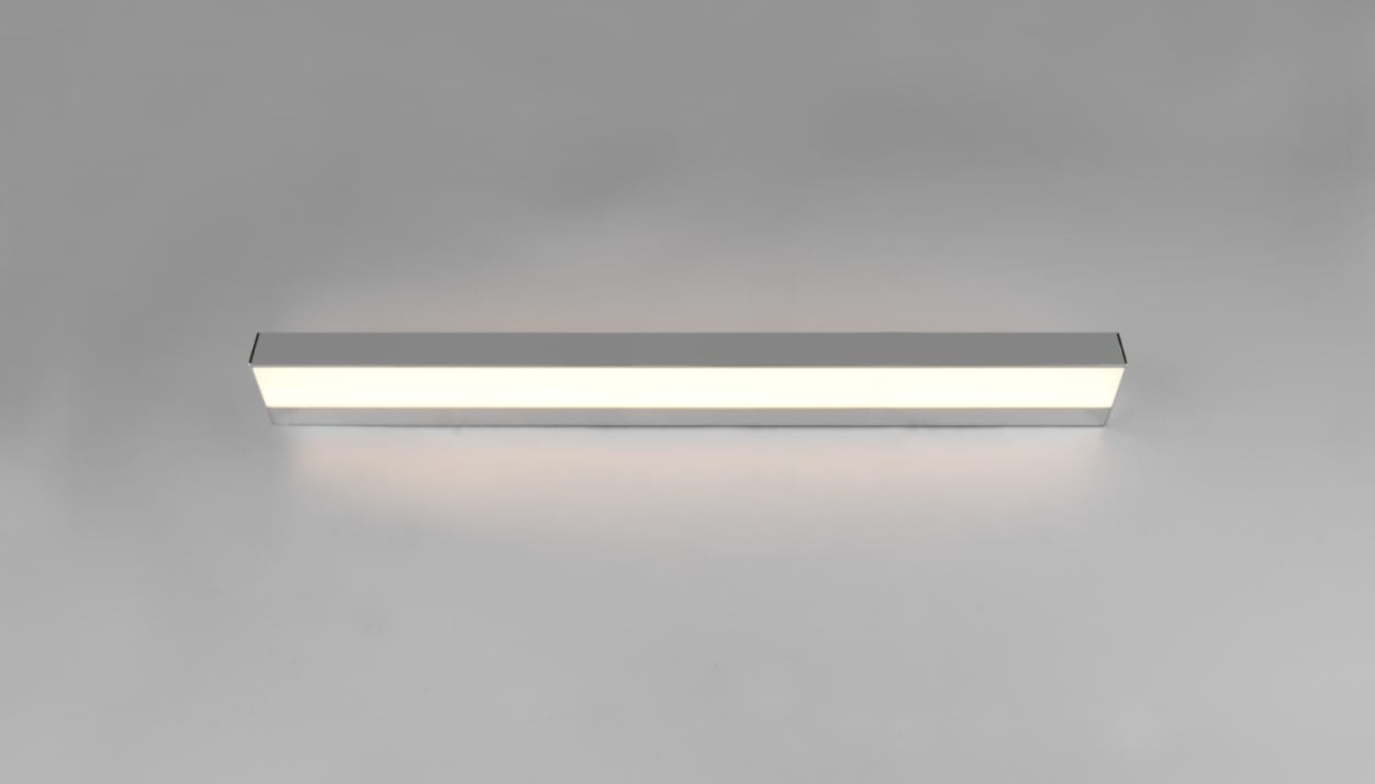 Kinkiet LED Rocco IP44 w kolorze chromu, prostokątny, o wymiarach 90 cm i mocy 13W. Zainstalowany na gładkiej, jasnej powierzchni, emituje równomierne, białe światło. Produkt ma minimalistyczny design, nadający się do nowoczesnych wnętrz.