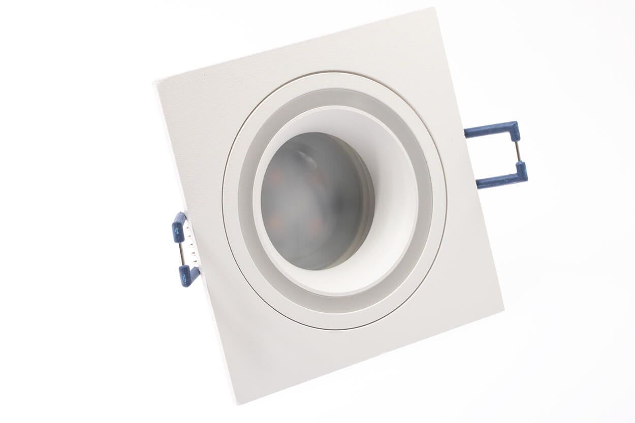 Kwadratowa oprawa oczko do zabudowy w kolorze białym, przeznaczona do żarówek GU10. Ujęcie z góry ukazuje wewnętrzny okrągły element oraz niebieskie zaczepy montażowe. Prosta forma, idealna do nowoczesnych wnętrz.