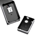 Czarny kinkiet elewacyjny Diron LED z czujnikiem ruchu, widok na wnętrze oprawy z białym złączem elektrycznym. Obudowa z tworzywa, widoczne otwory montażowe na dnie. Ujęcie z góry, pokazujące elementy instalacyjne oraz detale konstrukcyjne.