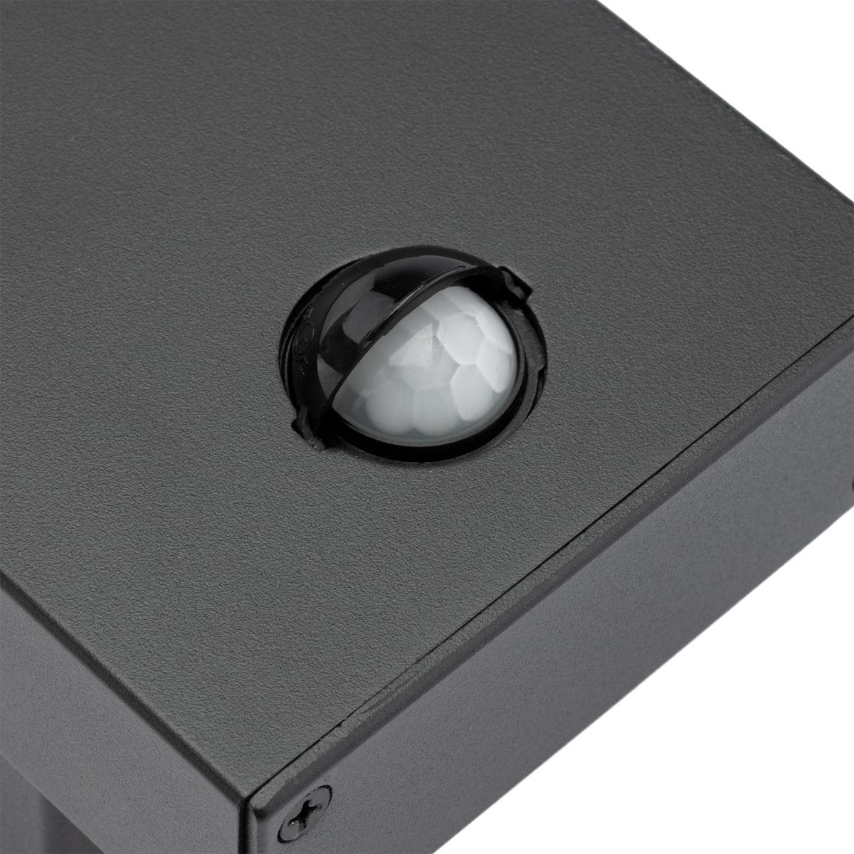 Grafitowy kinkiet elewacyjny Clark LED z widocznym czujnikiem ruchu. Produkt ma prostokątny kształt, matową fakturę i jest zamontowany na ścianie. Czujnik posiada okrągłą, półprzezroczystą soczewkę w czarnym otoku.