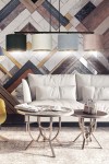 Lampa wisząca Hilde 4-punktowa w multikolorze, z czterema cylindrycznymi kloszami w różnych kolorach (ciemna zieleń, jasny beż, błękitny, różowy), zawieszona na czarnym stelażu, w nowoczesnym wnętrzu z sofą i okrągłymi stolikami.