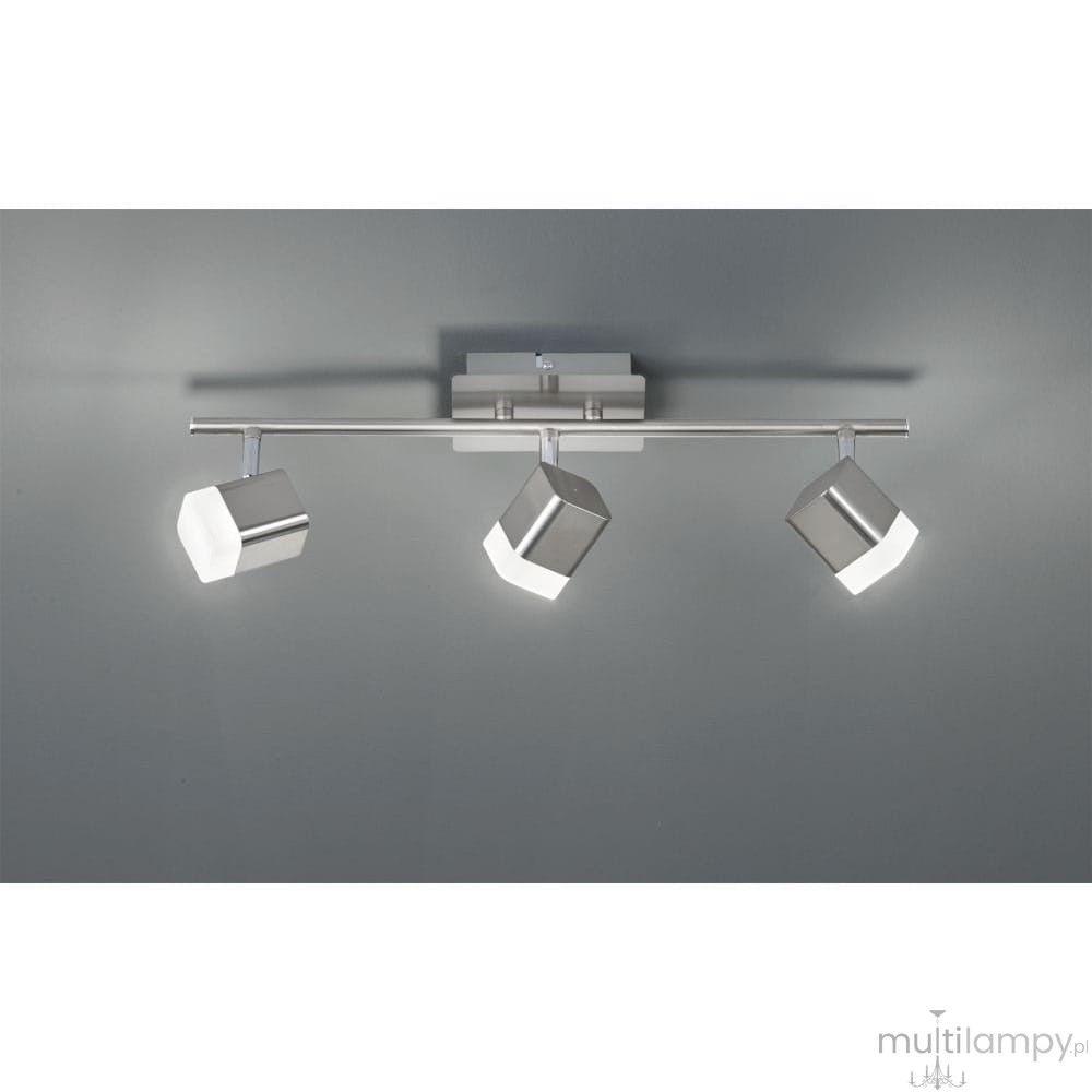 Lampa sufitowa Roubaix LED 3-punktowa w kolorze niklowym, z trzema kwadratowymi reflektorami. Montaż na suficie, z metalową listwą. Reflektory emitują jasne światło, skierowane w różnych kierunkach. Tło szare, proste.